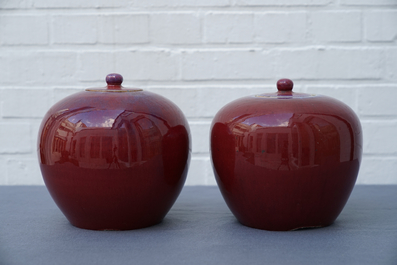 A pair of Chinese monochrome oxblood-glazed jars and covers, 19th C.